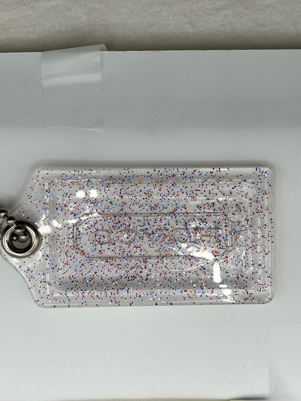 Coach Poppy Clear Glitter Hang Tag with Red, Blue, and Silver Speckles